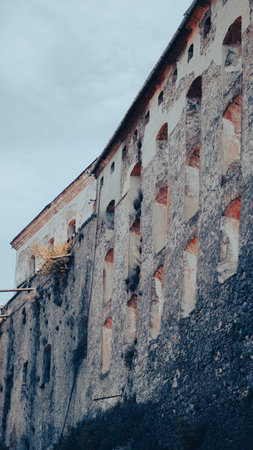 Old stone wall of a medieval castle with weathered surface and texturesの写真素材