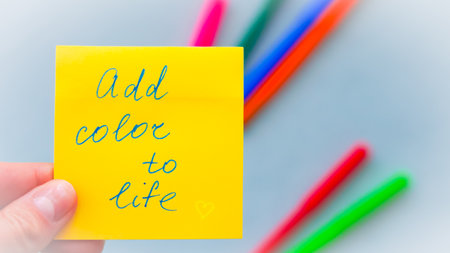 Bright sticky note with an uplifting message to inspire a colorful, vibrant mindsetの写真素材