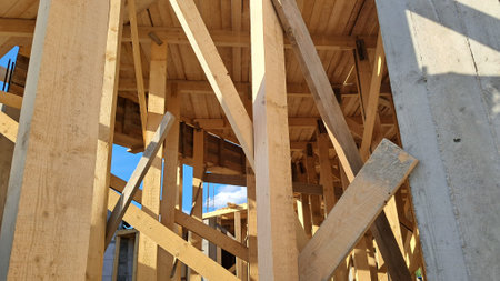 Timber framing on construction site under bright sunlight and blue skyの写真素材