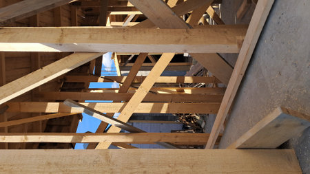 Timber framing on construction site under bright sunlight and blue skyの写真素材