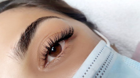 Close up of female eye with eyelash extensions,eyelash extension procedure.2d volume, 3d volume, classical lashes,Russian volume,mega volume, new set.の写真素材