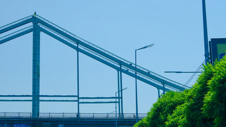 Minimalist pedestrian bridge underframe photographed from below in urban settingの写真素材
