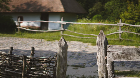 Authentic Ukrainian whitewashed hut with thatched roof and wooden fence.の写真素材