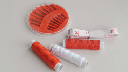 Flat lay of sewing tools including threads, pins and measure tape for DIY.の写真素材
