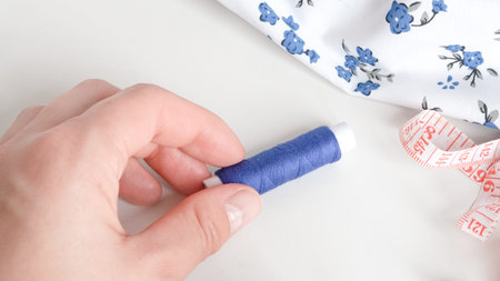 Colorful sewing threads with measuring tape on clean white background.