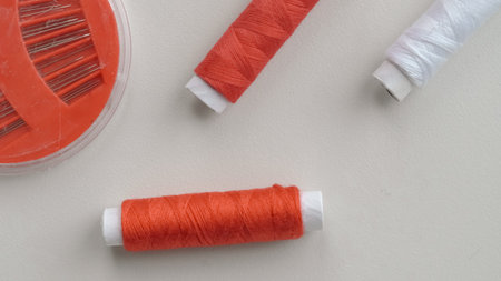 Thread spools in organizer with soft fabric on white background for sewing.
