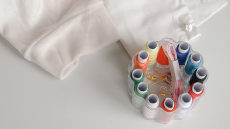Thread spools in organizer with soft fabric on white background for sewing.