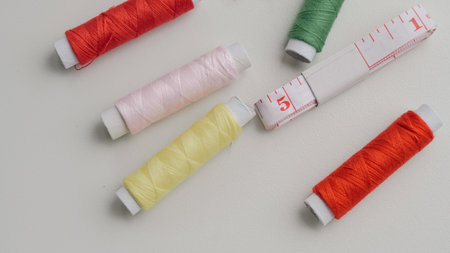 Basic sewing tools with colorful threads and tape for beginner's workshop.の写真素材