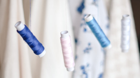 Colorful sewing threads with measuring tape on clean white background.の写真素材
