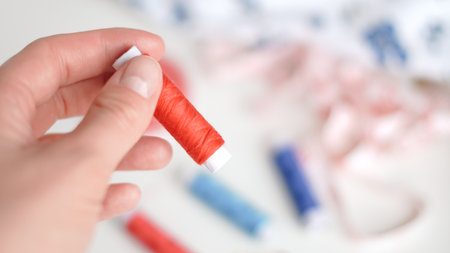 Colorful threads and tape arranged neatly on white background for crafting.の写真素材