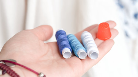 Colorful sewing threads and measuring tape on clean white background.の写真素材