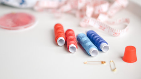 Colorful sewing threads and measuring tape on clean white background.の写真素材