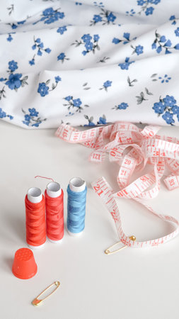Colorful sewing threads with measuring tape on clean white background.の写真素材