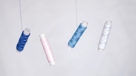 Colorful sewing threads with measuring tape on clean white background.