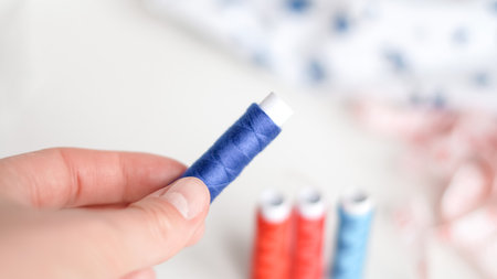 Sewing threads and measuring tape on white surface in neat composition.の写真素材