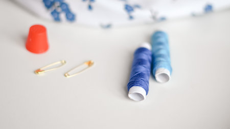Colorful sewing threads with measuring tape on clean white background.の写真素材