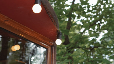 String lights hanging over cafe terrace with warm ambiance in urban space.の写真素材