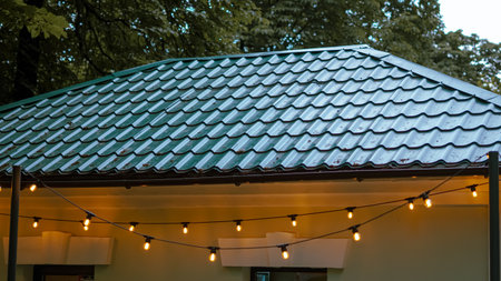 Hanging garland lights in evening urban cafe creating warm soft glow.の写真素材