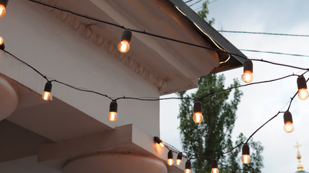 Cafe exterior with decorative light garlands creating a cozy street mood.の写真素材