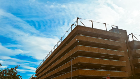 Modern open brick parking garage with multiple levels and clear sky background.の写真素材