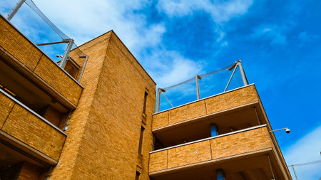 Urban facade texture with brick parking layers and blue sky as abstract background.の写真素材