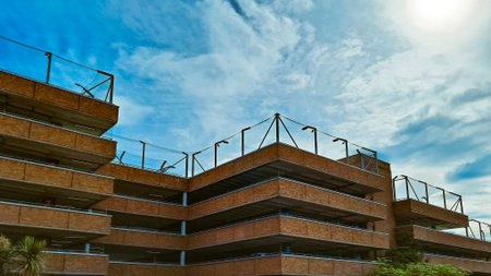 Modern open brick parking garage with multiple levels and clear sky background.の写真素材