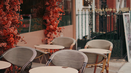 Charming outdoor cafe scene with flowers, elegant chairs, and cozy city moodの写真素材