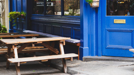 Traditional British pub interior with wooden tables and rich blue painted walls.