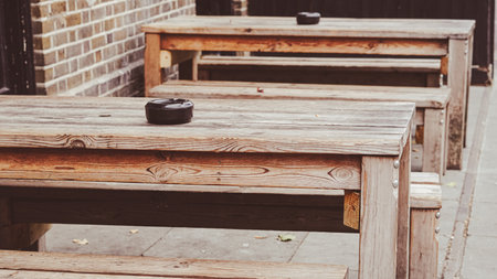 Traditional outdoor pub furniture with wooden tables in an inviting settingの写真素材