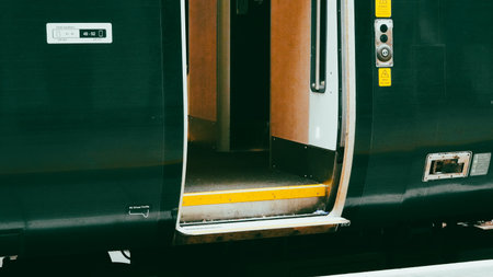 Side view of a green passenger train moving along tracks in the countrysideの写真素材
