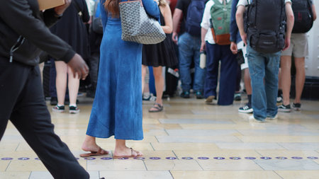 Low angle shot of walking people with travel bags at station in transit momentの写真素材