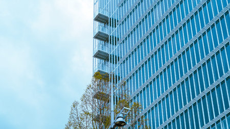 Glass buildings and geometric shapes in modern blue architecture background.