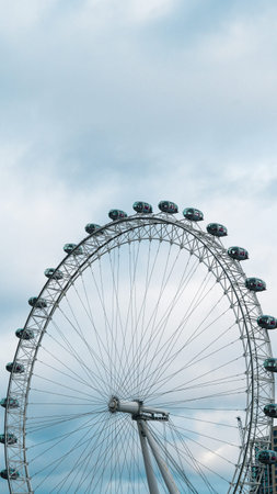 London Eye with gray clouds above river Thames cityscape urban sightseeing spot