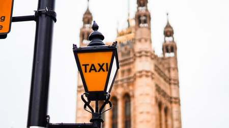 Taxi sign lantern glowing on English street pole urban night viewの写真素材