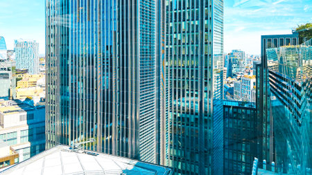 Urban skyline panorama with tall glass buildings under blue sky.の写真素材