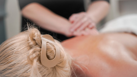 Close massage work creating a soothing moment for blonde woman in salon.の写真素材