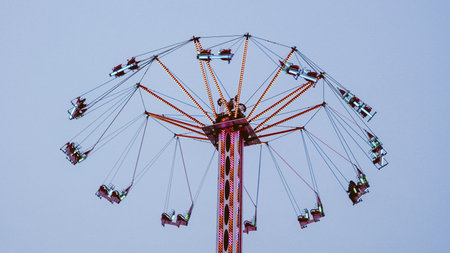 Swing carousel ride at amusement park against clear sky, motion and funの写真素材