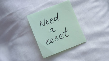 Handwritten note saying Need a reset placed on a white surface for emphasis on emotional burnout