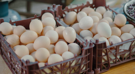 Multiple crates filled with fresh eggs arranged on a wooden table in a market setting