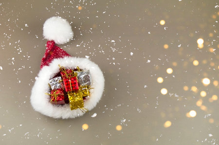 Santa Claus hat with gifts on a gray background