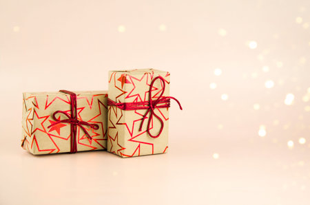 Gifts tied with a red ribbon on a pink background.