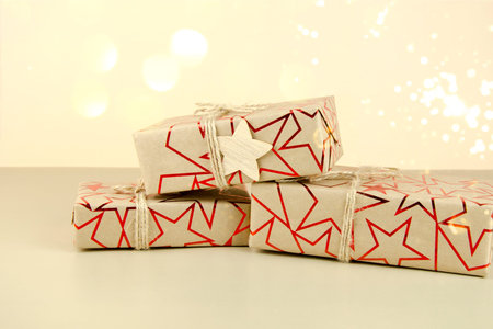 Gifts tied with a red ribbon on a pink background.