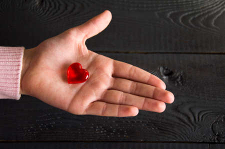 A red heart in a child's handの写真素材