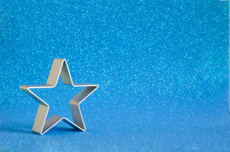 The shape of a cookie star on a blurry blue backgroundの写真素材