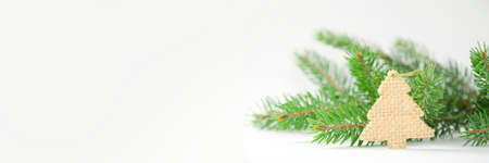 Wooden decoration on the background of a fir branch. Bannerの写真素材