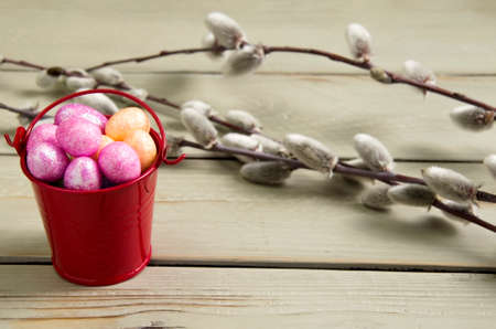 Easter shiny eggs in a bucket on a wooden backgroundの写真素材