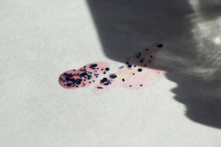 A drop of nail polish spilled on a light surfaceの写真素材