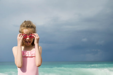 Girl on the beach wearing goggles for swimmingの写真素材