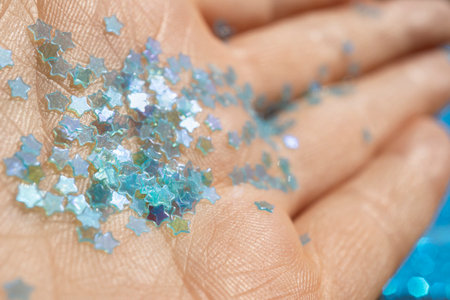 Bright golden sequins on the handの写真素材