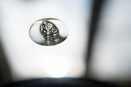 A drop of transparent cosmetic product on a gray background.